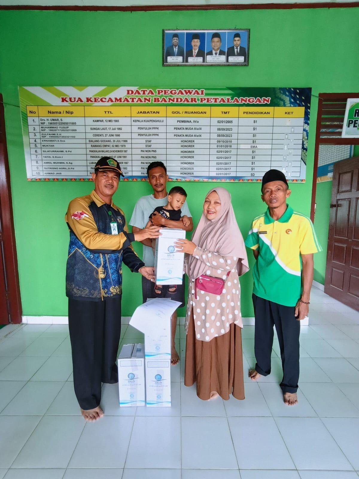 Kepala KUA Langgam dan Bandar Petalangan Bagikan Air Zam-Zam untuk Keluarga Jamaah Haji
